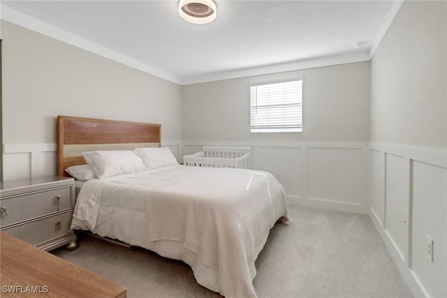 bedroom featuring ornamental molding and light carpet