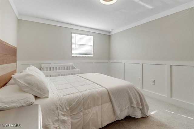 carpeted bedroom with ornamental molding