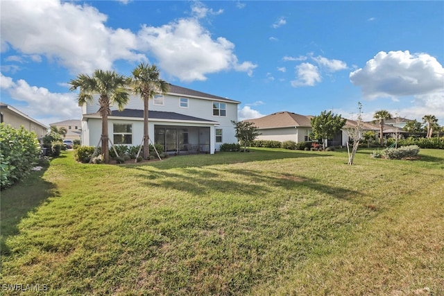 back of property with a yard and a sunroom