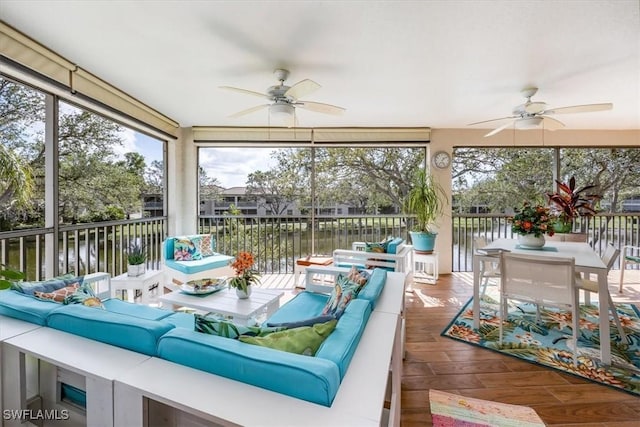 sunroom with a water view and ceiling fan