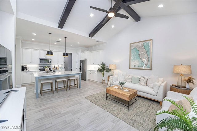 living room with ornamental molding, light hardwood / wood-style flooring, lofted ceiling with beams, and ceiling fan