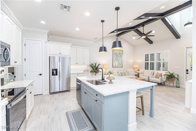 kitchen featuring sink, a center island with sink, hanging light fixtures, stainless steel appliances, and white cabinets