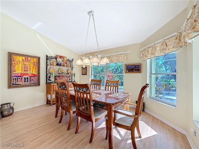 dining room with a wealth of natural light, a notable chandelier, and light wood-type flooring