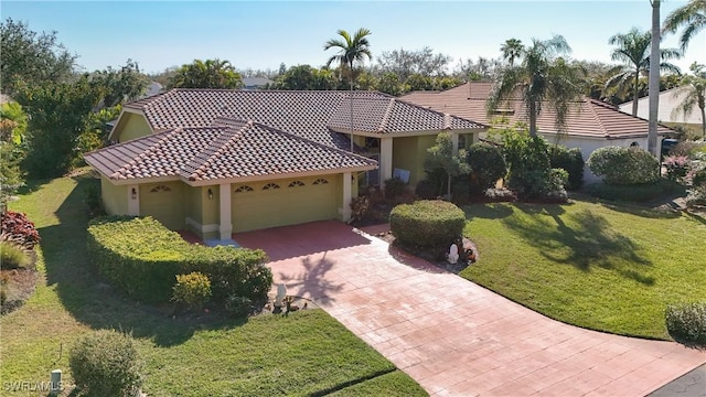 mediterranean / spanish home with a garage and a front lawn