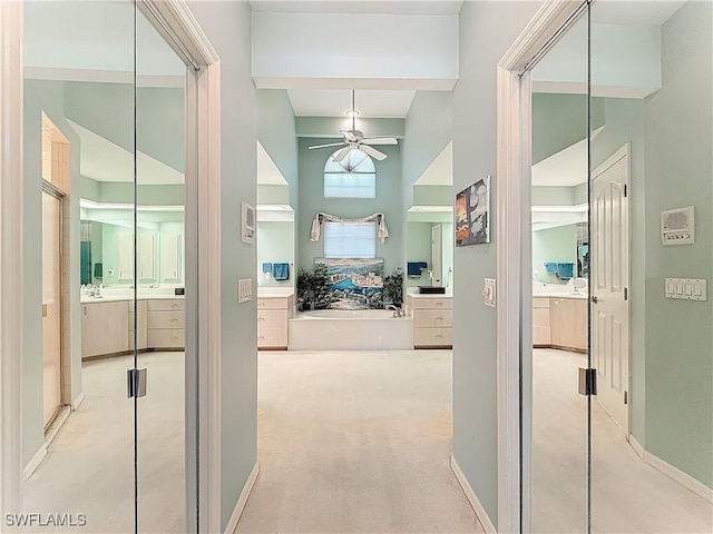 corridor featuring a towering ceiling and light carpet