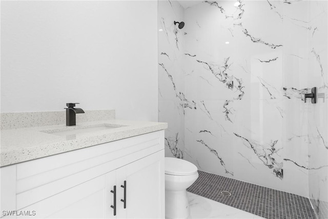 bathroom featuring vanity, tiled shower, and toilet