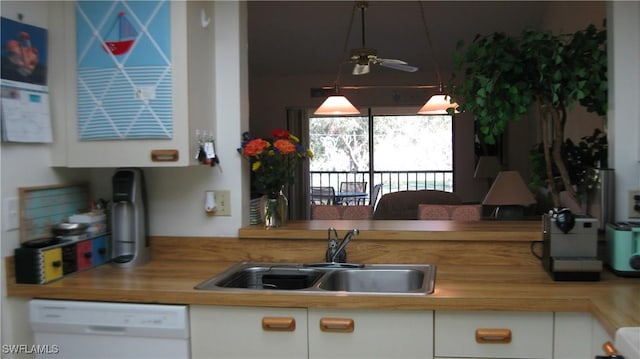 kitchen with white cabinetry, wooden counters, white dishwasher, and sink