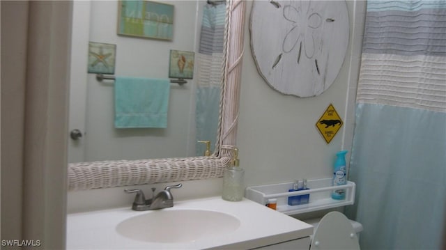 bathroom featuring a shower with curtain, vanity, and toilet