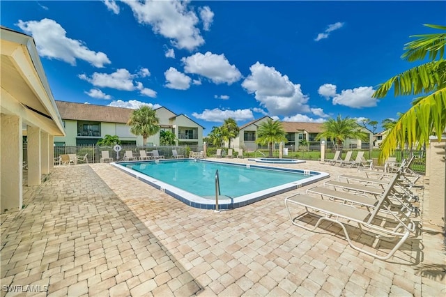 view of swimming pool with a patio area and a community hot tub