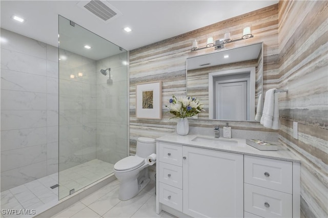 bathroom featuring tiled shower, vanity, toilet, and tile walls