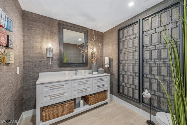 bathroom featuring vanity, hardwood / wood-style floors, and toilet