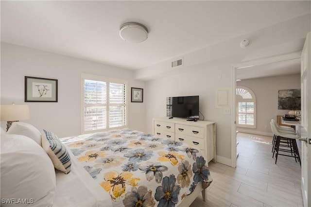 bedroom with multiple windows and light wood-type flooring