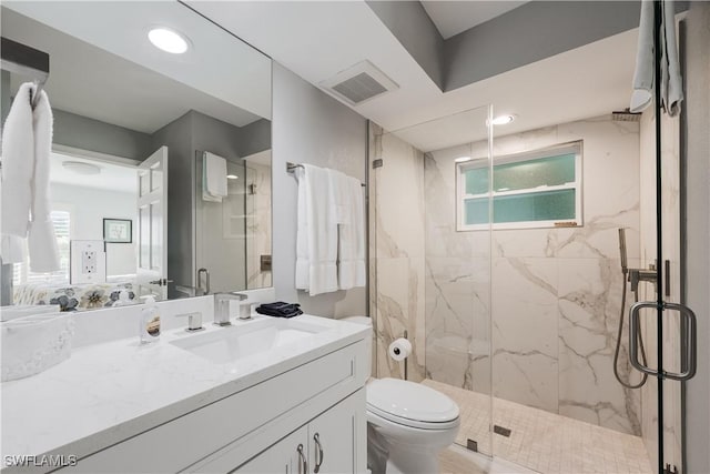 bathroom with a shower with door, vanity, and toilet