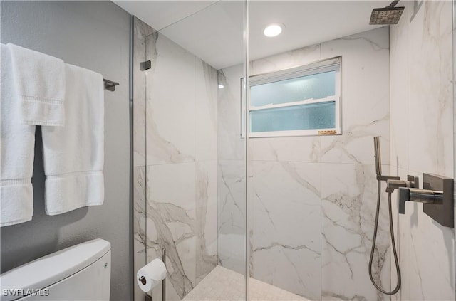 bathroom featuring tiled shower and toilet