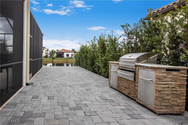 5222 N Ferrari Ave, Ave Maria, FL 34142 - view of patio / terrace featuring a grill, a water view, and an outdoor kitchen