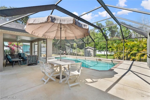 view of pool with a lanai, ceiling fan, and a patio area