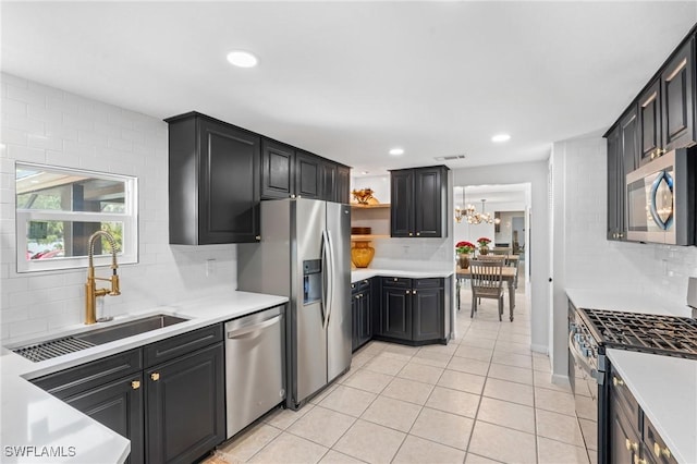 kitchen featuring stainless steel appliances, sink, light tile patterned floors, and decorative backsplash