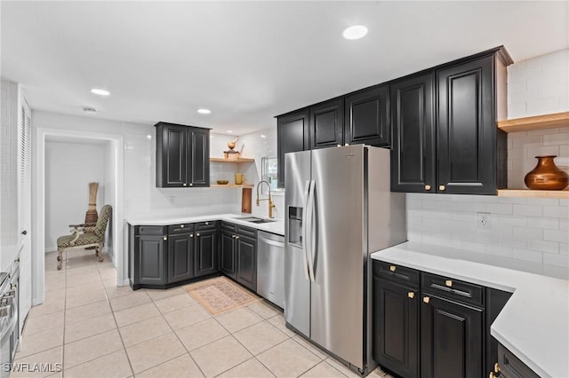 kitchen with sink, light tile patterned floors, stainless steel appliances, and decorative backsplash