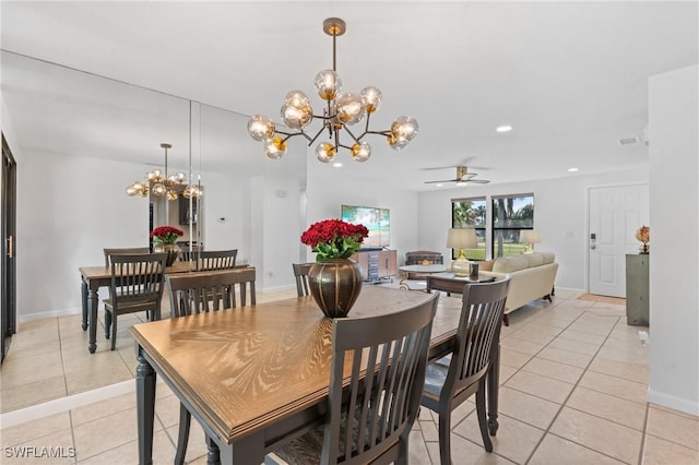 dining space with ceiling fan with notable chandelier and light tile patterned floors