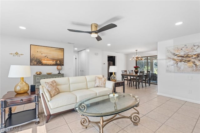 tiled living room with ceiling fan with notable chandelier