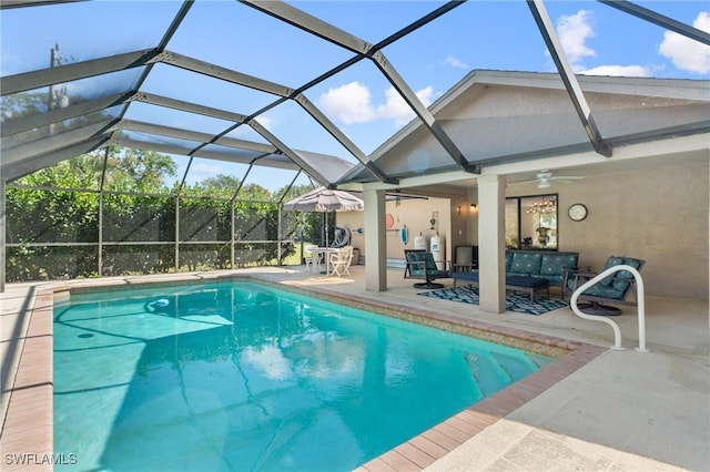 view of pool with ceiling fan, a patio, outdoor lounge area, and glass enclosure