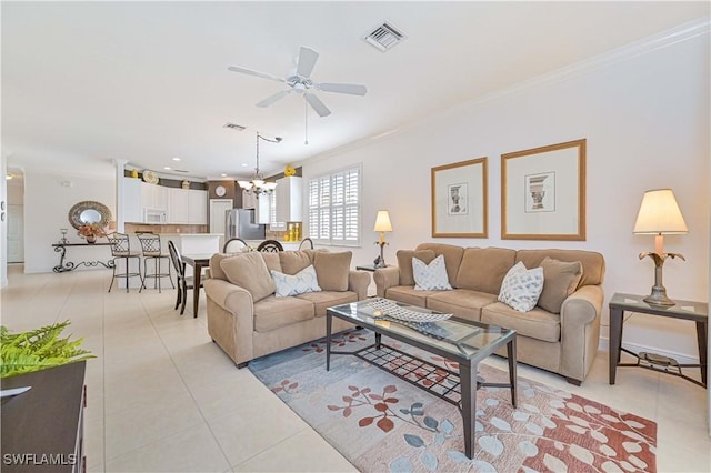 tiled living room featuring crown molding and ceiling fan with notable chandelier