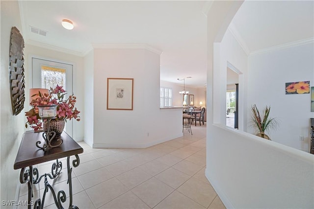 hallway featuring ornamental molding, light tile patterned floors, and an inviting chandelier