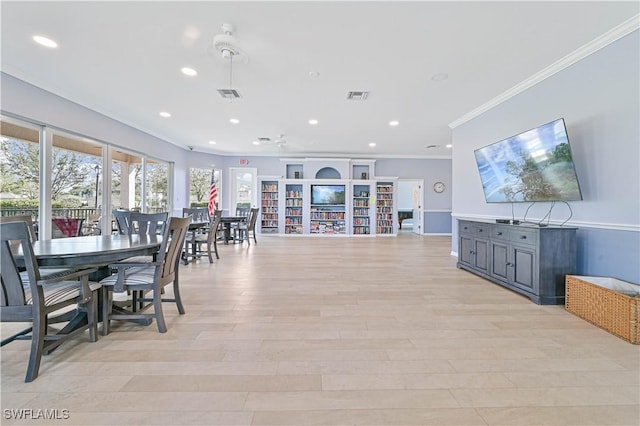 dining room with crown molding and light hardwood / wood-style floors