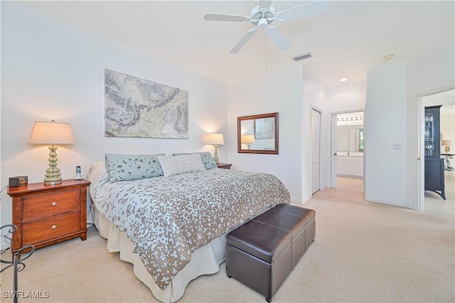 bedroom with ceiling fan, a closet, ensuite bath, and light carpet