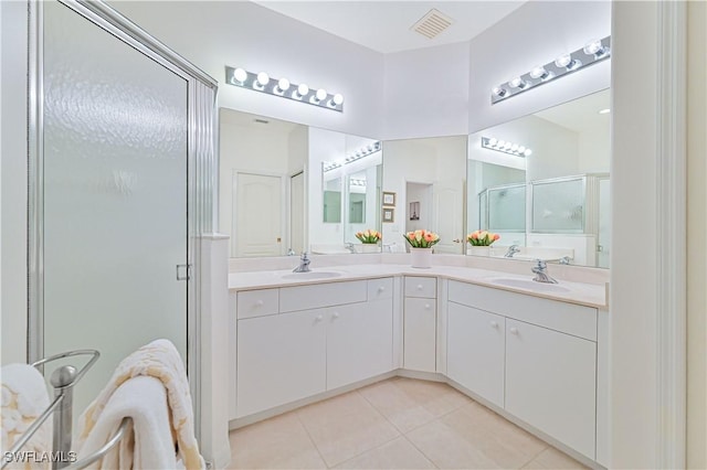 bathroom with tile patterned floors, a shower with door, and vanity