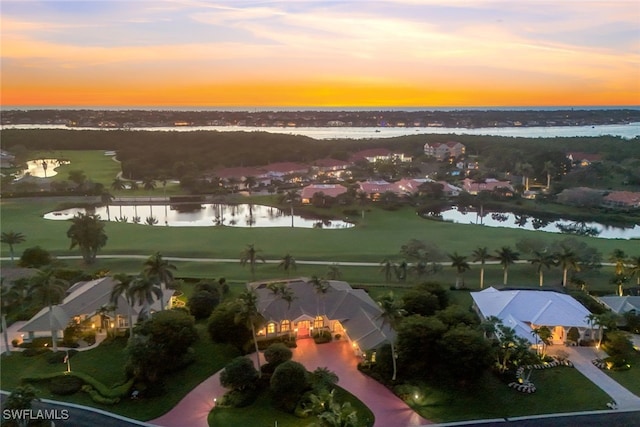 aerial view at dusk featuring a water view