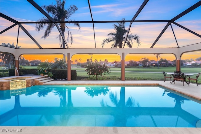 view of swimming pool featuring a lanai, a pool with connected hot tub, and a patio