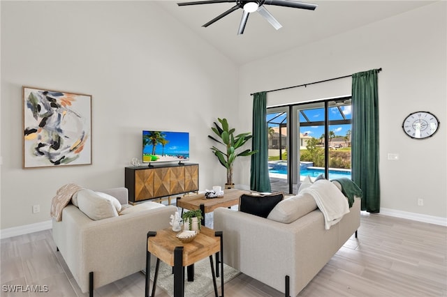 living room with ceiling fan, high vaulted ceiling, and light hardwood / wood-style floors