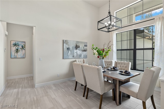 dining room featuring a towering ceiling and a chandelier