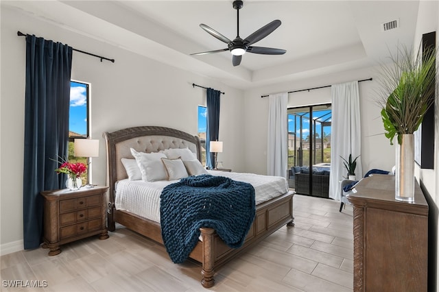 bedroom with access to outside, a raised ceiling, and ceiling fan