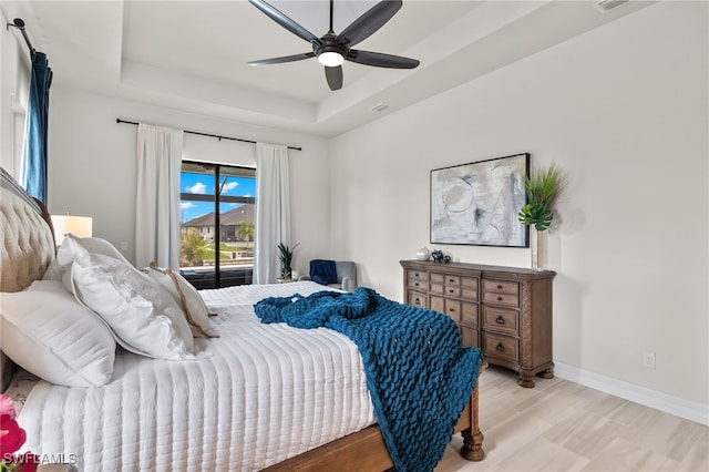 bedroom with a raised ceiling, access to outside, and ceiling fan