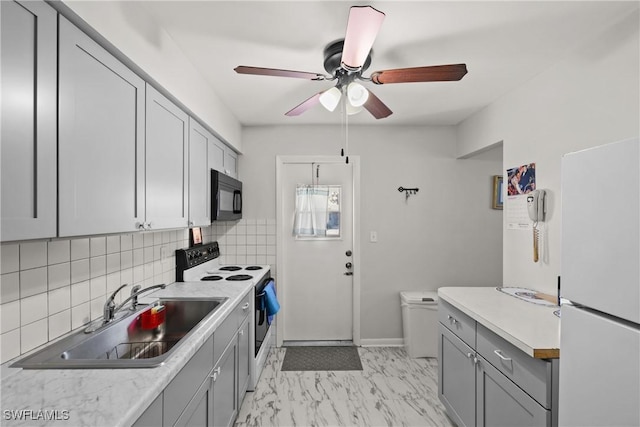 kitchen with sink, white appliances, ceiling fan, gray cabinetry, and decorative backsplash