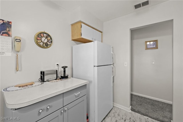 kitchen with gray cabinets and white fridge