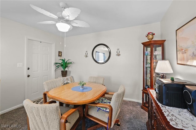 dining room featuring ceiling fan and dark carpet