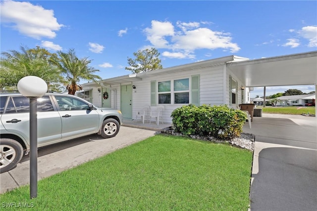 view of front of property with a carport and a front lawn