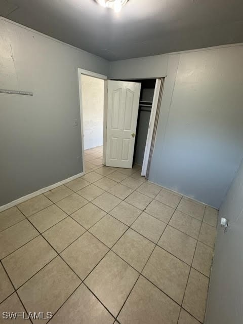 unfurnished bedroom with light tile patterned floors and a closet