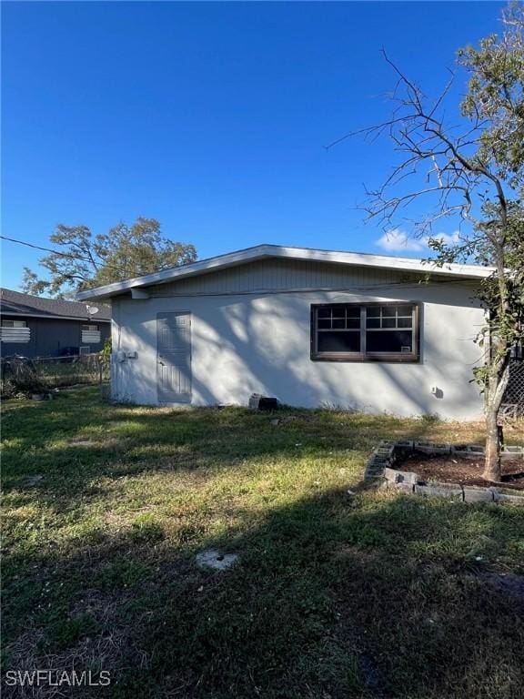 view of side of home with a lawn