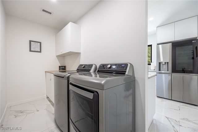 laundry room featuring cabinets and washing machine and dryer