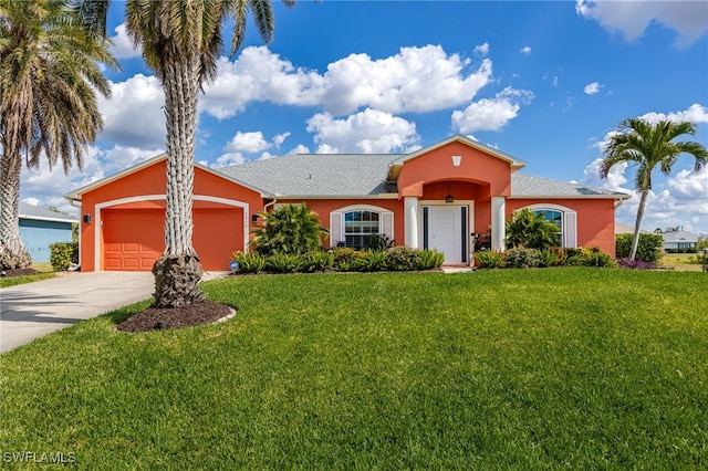 view of front of property featuring concrete driveway, an attached garage, a front lawn, and stucco siding