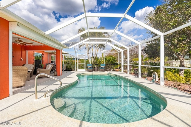 view of swimming pool featuring outdoor lounge area, a patio, ceiling fan, and glass enclosure