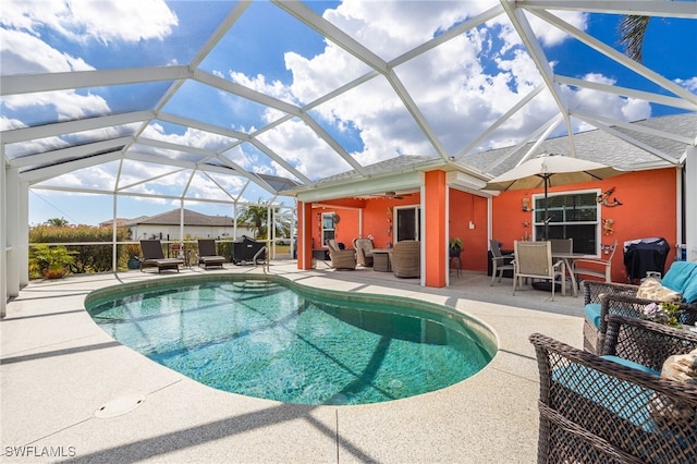 view of pool featuring ceiling fan, a patio, outdoor lounge area, and glass enclosure