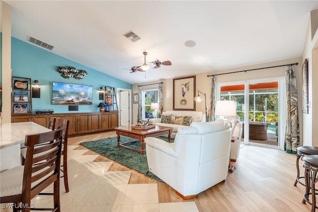 living room with plenty of natural light, lofted ceiling, ceiling fan, and light hardwood / wood-style floors