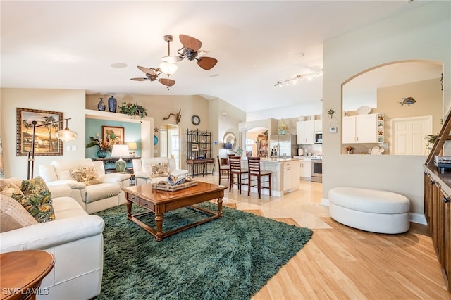 living room featuring vaulted ceiling, ceiling fan, and light hardwood / wood-style floors