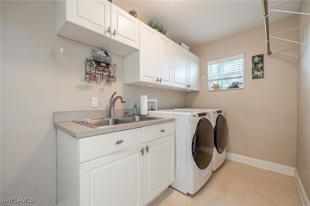 laundry area featuring sink, light tile patterned floors, cabinets, and washing machine and clothes dryer