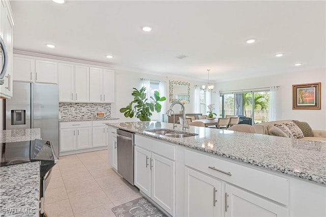 kitchen with sink, white cabinetry, light tile patterned floors, appliances with stainless steel finishes, and pendant lighting